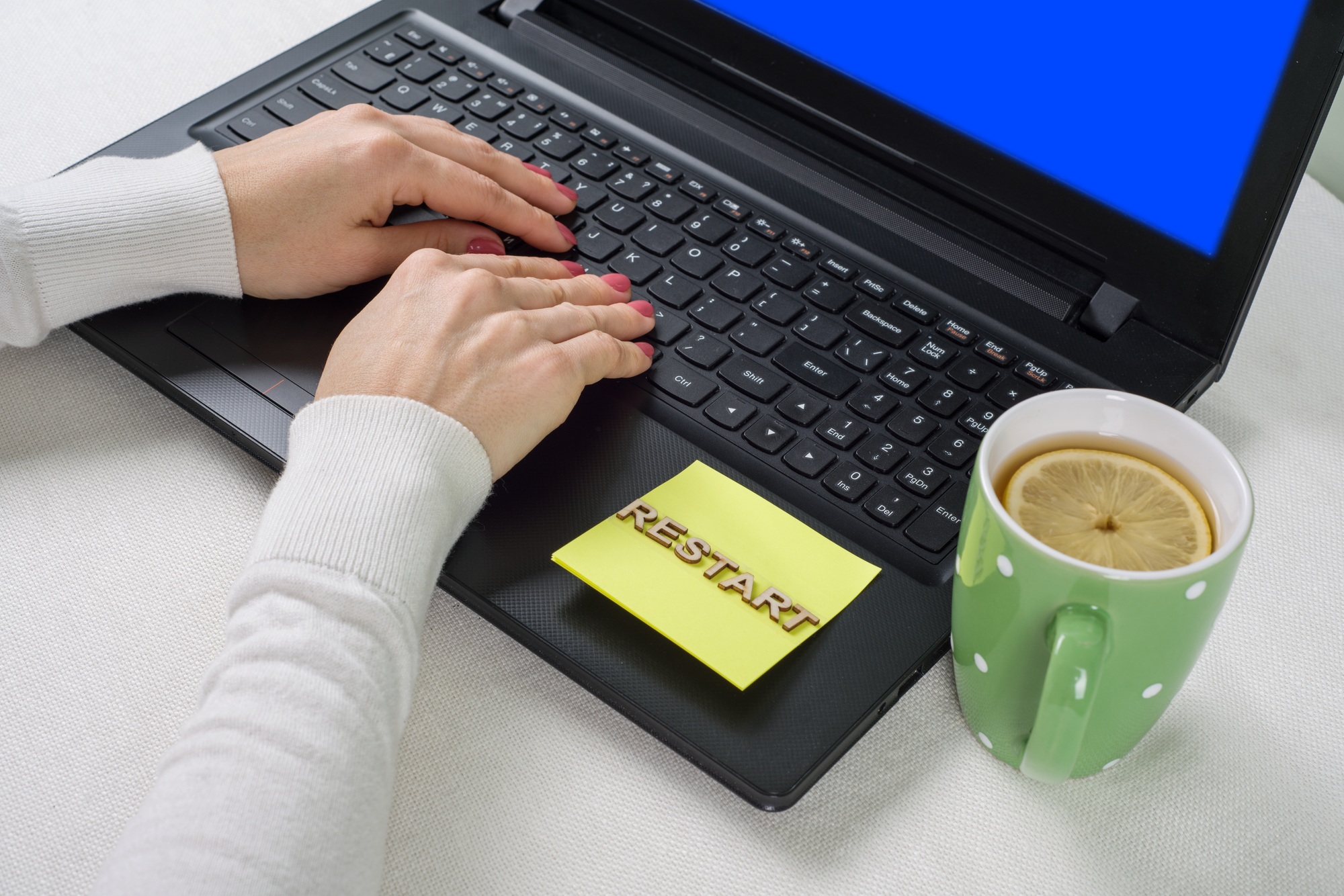 Blue screen of death, background laptop on the desktop and sticker restart